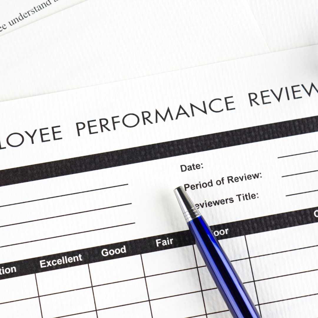 A close-up of a stress-free employee performance review form. The form includes sections for date, review period, and reviewer's title, complete with a rating scale from excellent to poor. A blue pen casually rests on the form, inviting thoughtful assessment without stress.