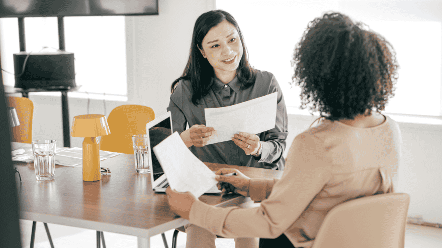 : Business leader working with Executive Assistant in modern office discussing strategic role creation and operational efficiency